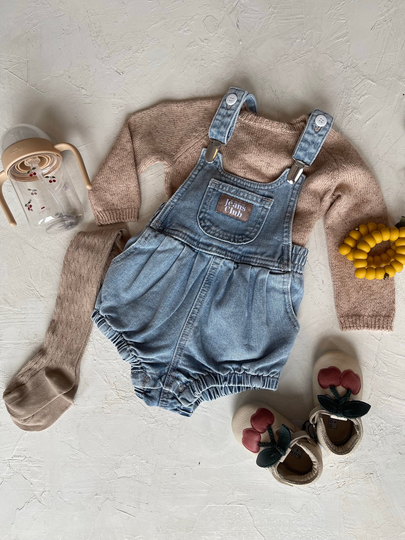 Baby overalls with leather cherry shoes and a lemon teether