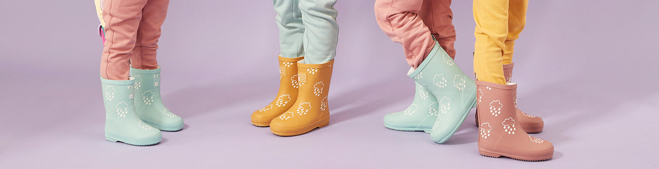 Kids modeling Grass and Air wellies in teal, yellow, and pink