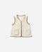 A cream-colored sherpa fleece vest with tan trim and button details, displayed flat against a light gray background.
